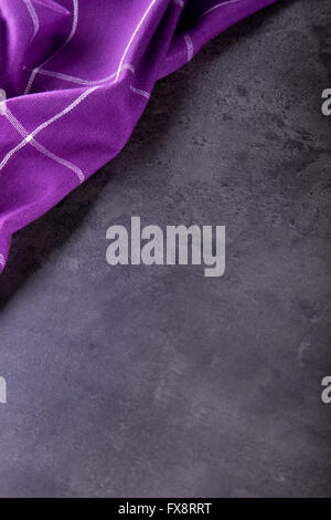 Top view of checkered kitchen purple tablecloth on concrete - stone - marble - wooden background. Free space for your text or pr Stock Photo