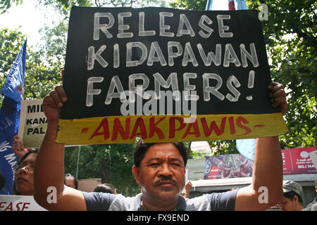 Philippines. 13th Apr, 2016. A protester holding a poster in front of the Department of Justice in Manila. Protesters lead by the group Bayan called for the unconditional release of the 71 farmers that were arrested following the violent dispersal last April 1, that left 2 dead and several people injured. According to Karapatan, a human rights group monitoring the detainees, a 6 month pregnant woman and a 78 year old lady are among the detainees. Credit:  J Gerard Seguia/ZUMA Wire/Alamy Live News Stock Photo