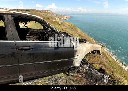 Burnt out car on cliff edge at Portland, Dorset, UK Stock Photo