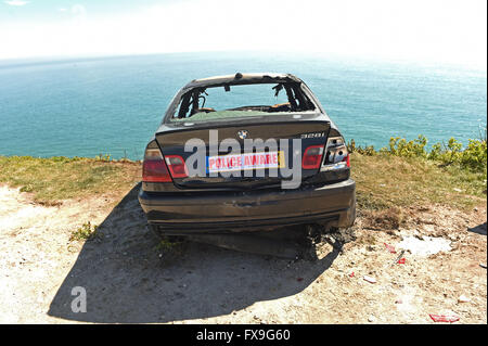 Burnt out car on cliff edge at Portland, Dorset, UK Stock Photo