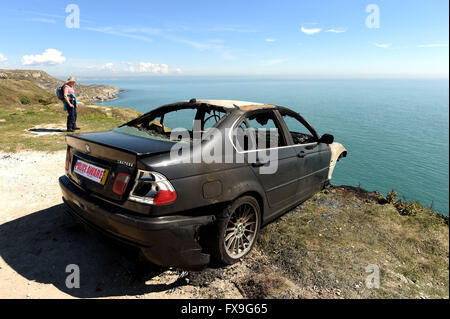 Burnt out car on cliff edge at Portland, Dorset, UK Stock Photo