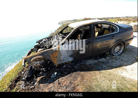 Burnt out car on cliff edge at Portland, Dorset, UK Stock Photo