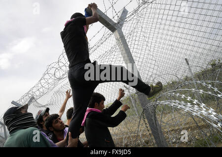 Eidonemi, Greece. 13th Apr, 2016. Greece/Macedonia border Idomeni/Gevgelija April 13 2016:hundreds of migrants have tried today to break through the barrier that divides them from Macedonia, the police responded with tear gas, rubber bullets and sound bombs after the migrants have managed to break through the fence. dozens injured and intoxicated by tear gas. Credit:  Danilo Balducci/ZUMA Wire/Alamy Live News Stock Photo