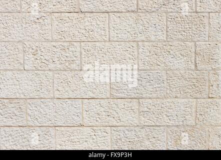 Texture of vertical wall built of rough beige stone blocks Stock Photo