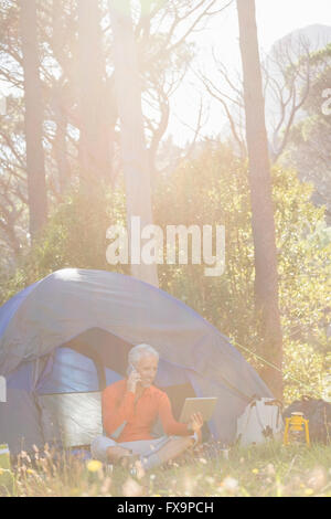 Mature man holding tablet and calling on the phone Stock Photo
