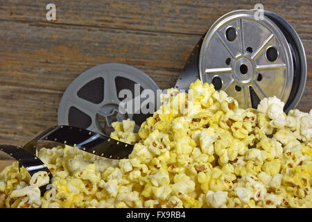 Vintage movie reels and film in a pile of popcorn. Stock Photo