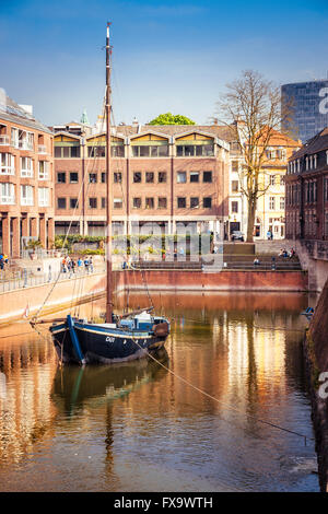 DUSSELDORF, GERMANY - MAY 3, 2013: Boat in harbor in Dusseldorf in Germany. Tourists nearby. Stock Photo