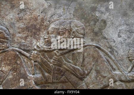 Slab.Transportation of timber (cedars of Lebanon). Men are pulling a load with a rope. Palace of Sargon II, Khorsabad. Iraq. Stock Photo