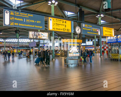 Information signs and people in train terminal of Schiphol Amsterdam Airport, Netherlands Stock Photo