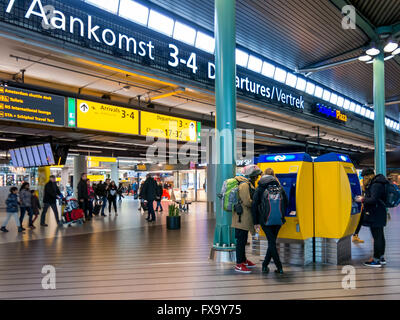 Tourists and travellers at Schiphol Amsterdam Airport train terminal, Netherlands Stock Photo