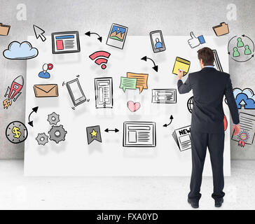 Composite image of businessman standing back to camera writing with marker Stock Photo