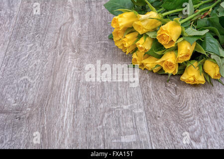 Yellow roses on a grey wooden background Stock Photo