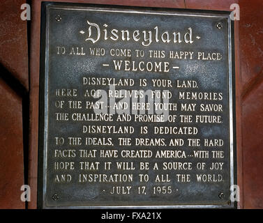 A dedication plaque commemorates the grand opening of the world’s most famous theme park, Disneyland, on July 17, 1955, in Anaheim, California, USA.  The metal tablet features a welcome “to this happy place” by Disneyland’s namesake creator, Walt Disney, who read the inscription to thousands of first-day guests and a nationwide audience during a ceremony on live television.  Today’s park visitors will find the plaque at the base of the pole flying the American flag at the south end of Main Street, U.S.A. Stock Photo