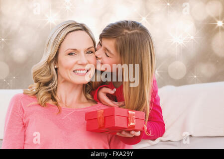 Composite image of smiling mother being kissing by daughter Stock Photo