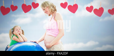 Composite image of smiling pregnant woman with young daughter Stock Photo
