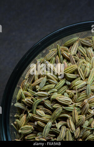 Curve of glass bowl full of fennel seeds with copy space in upper left Stock Photo