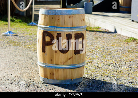 Kaseberga, Sweden - April 1, 2016: The word pub written on a wooden keg or cask. Part of a pub entrance in the background. Stock Photo