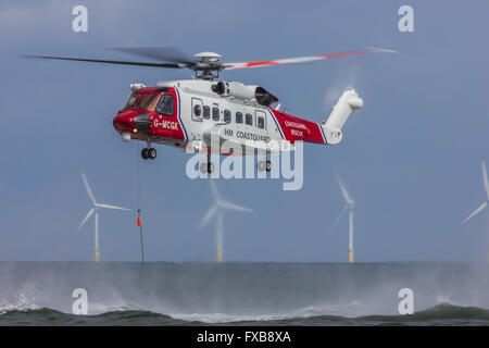 HM Coastguard rescue helicopter operating off the North Wales coast with the Gwynt y Mor windfarm in the background. Stock Photo