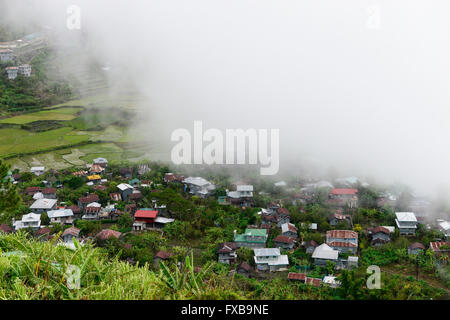 PHILIPPINES, Mountain Province, Cordilleras, rice farming on rice terrace in mountains near Sagada, village in clouds / PHILIPPINEN, Mountain Province, Cordilleras, Reisanbau und Reisfelder in Terrassen in den Bergen bei Sagada, Dorf im Nebel, in den Wolken Stock Photo