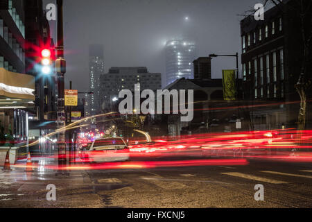 A long exposure of a busy Philadelphia street on a foggy night, light trails from cars visible. Stock Photo