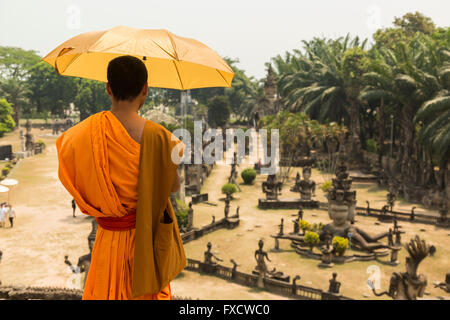 Vientiane, Laos - March 2015. A monk contemplating the statues at Buddha Park. Stock Photo