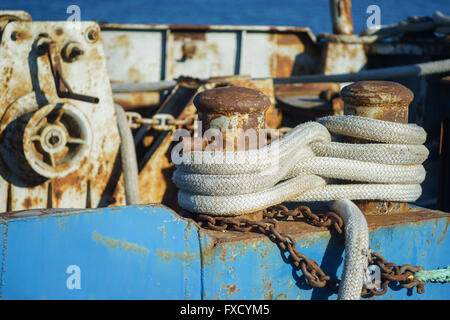 Rusted mooring bollard with naval ropes on old ship Stock Photo