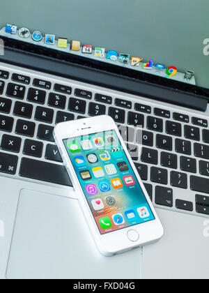 iphone SE on Apple Macbook Pro keyboard Stock Photo