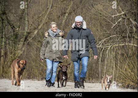 man and woman with 3 dogs Stock Photo