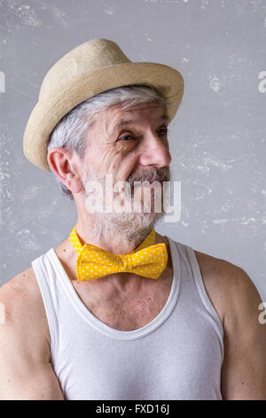 Funny senior man with a hat and bow tie around his neck Stock Photo