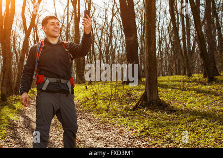 Man hiker taking photo with smart phone in forest Stock Photo