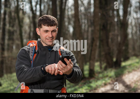 Man hiker taking photo with smart phone in forest Stock Photo