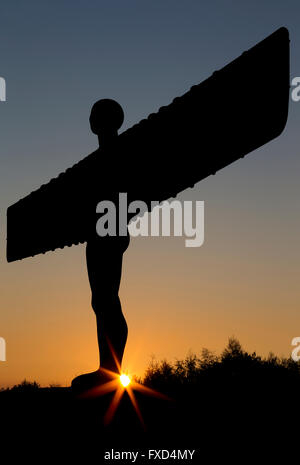 The Angel of the North in Gateshead at sunset with the setting sun clearly visible in a clear sky Stock Photo