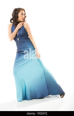 Beautiful young woman standing full length in vintage blue dress, dramatically stepping to one side with hand on shoulder. Stock Photo
