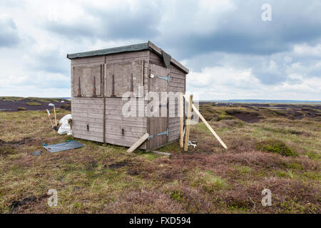 Unexpected hut in the middle of nowhere. A wooden shed used by workers restoring moorland, Kinder Scout, Derbyshire, England, UK Stock Photo