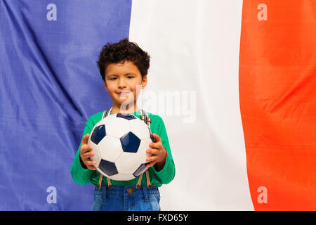 Little football fan with ball against French flag Stock Photo