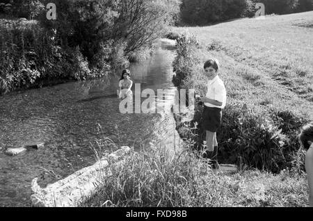 Deutsche Schauspielerin Margot Mahler bei einem Fotoshooting im Bach, Deutschland 1960er Jahre. German actress Margot Mahler posing for a photo shoot in a creek, Germany 1960s. 24x36swNeg399 Stock Photo