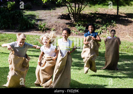 Children having a sack race in park Stock Photo