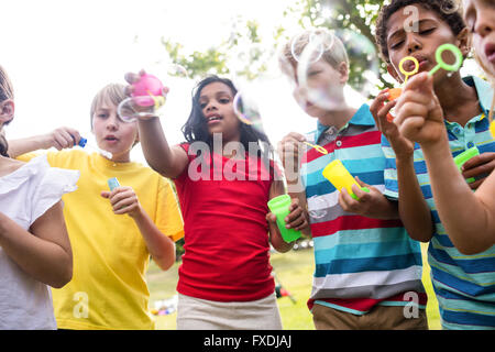 Children blowing bubbles wand in the park Stock Photo