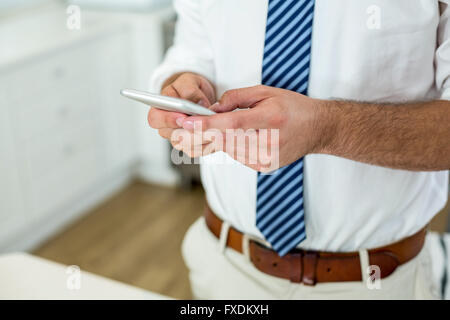 Businessman using mobile phone by table at home Stock Photo