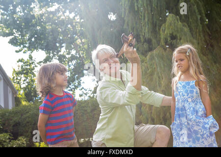 Playful grandfather playing with grandchildren at yard Stock Photo