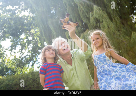 Happy grandfather playing with grandchildren at yard Stock Photo