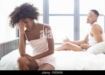 Upset couple ignoring each other after fight on bed Stock Photo