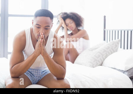 Upset couple ignoring each other after fight on bed Stock Photo