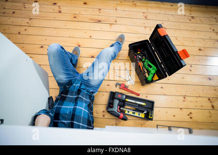 Man fixing kitchen sink Stock Photo