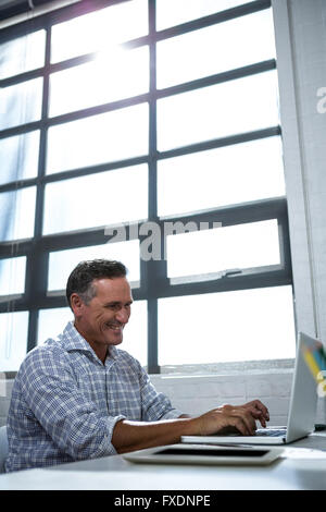 Man using laptop in office Stock Photo