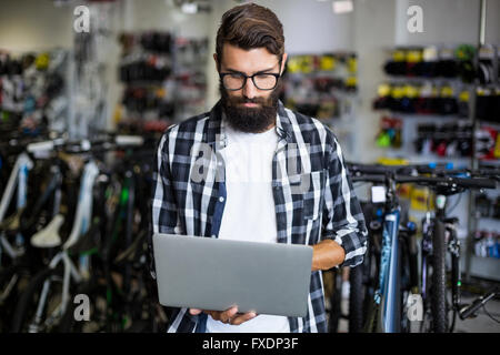 Bike mechanic checking laptop Stock Photo