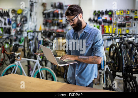 Bike mechanic checking at laptop Stock Photo