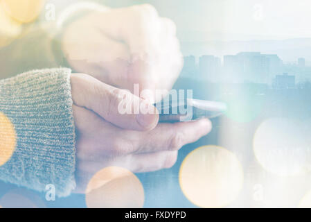 Man sending text message on smartphone, morning sunlight through the window, male hands using mobile phone device Stock Photo