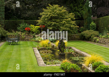 A beautiful, private, traditional, landscaped, country garden, West Yorkshire, England  - ornamental pond, fountain, seating area and striped lawn.