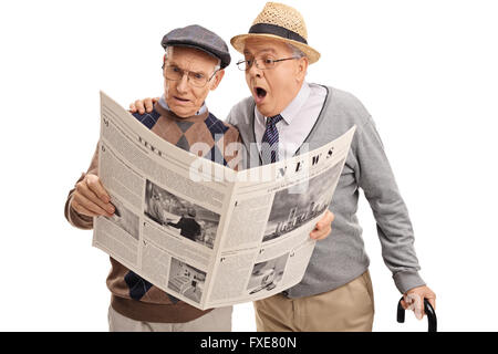 Two baffled senior gentlemen reading a newspaper isolated on white background Stock Photo